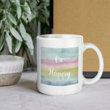White ceramic mug with "Be Happy" watercolor design. Customizable gift idea for daily use. Made in USA. Perfect gift.