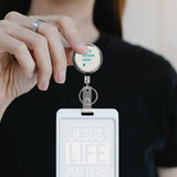 Personalized stainless steel badge reel holder with 'R DESIGN HERE' and 'JESUS LIFE MATTERS' ID card.