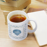 White ceramic mug with blue seashell design and tea, perfect gift