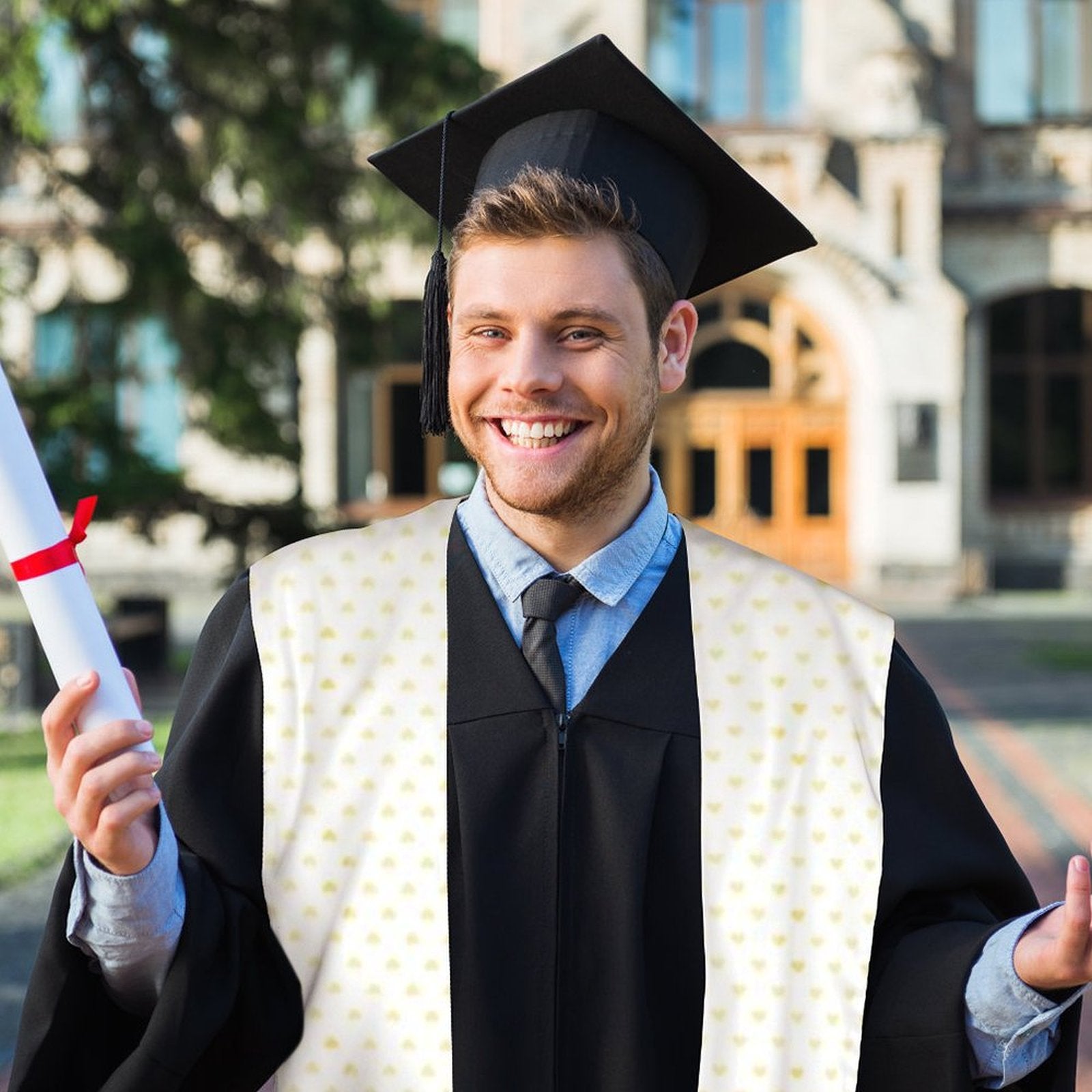 Happy graduate wearing graduation stole with yellow heart pattern, holding diploma. Custom senior gift.