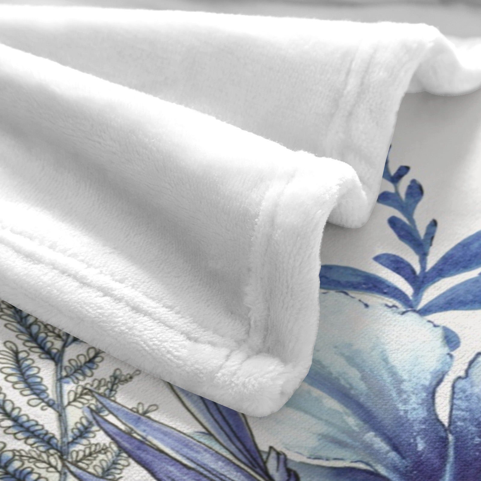 Soft white flannel blanket with blue tropical plant design, polyester made in USA, cozy home decor.