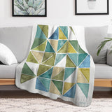 Green, blue, and beige geometric fleece blanket. Soft lamb wool, perfect for bed or couch, featuring "WILD APPLES".