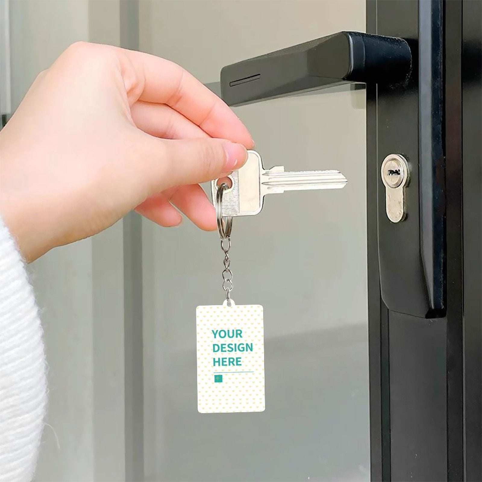 Customizable acrylic keychain with 'YOUR DESIGN HERE' design, connected to a key, perfect for personalized gifts.