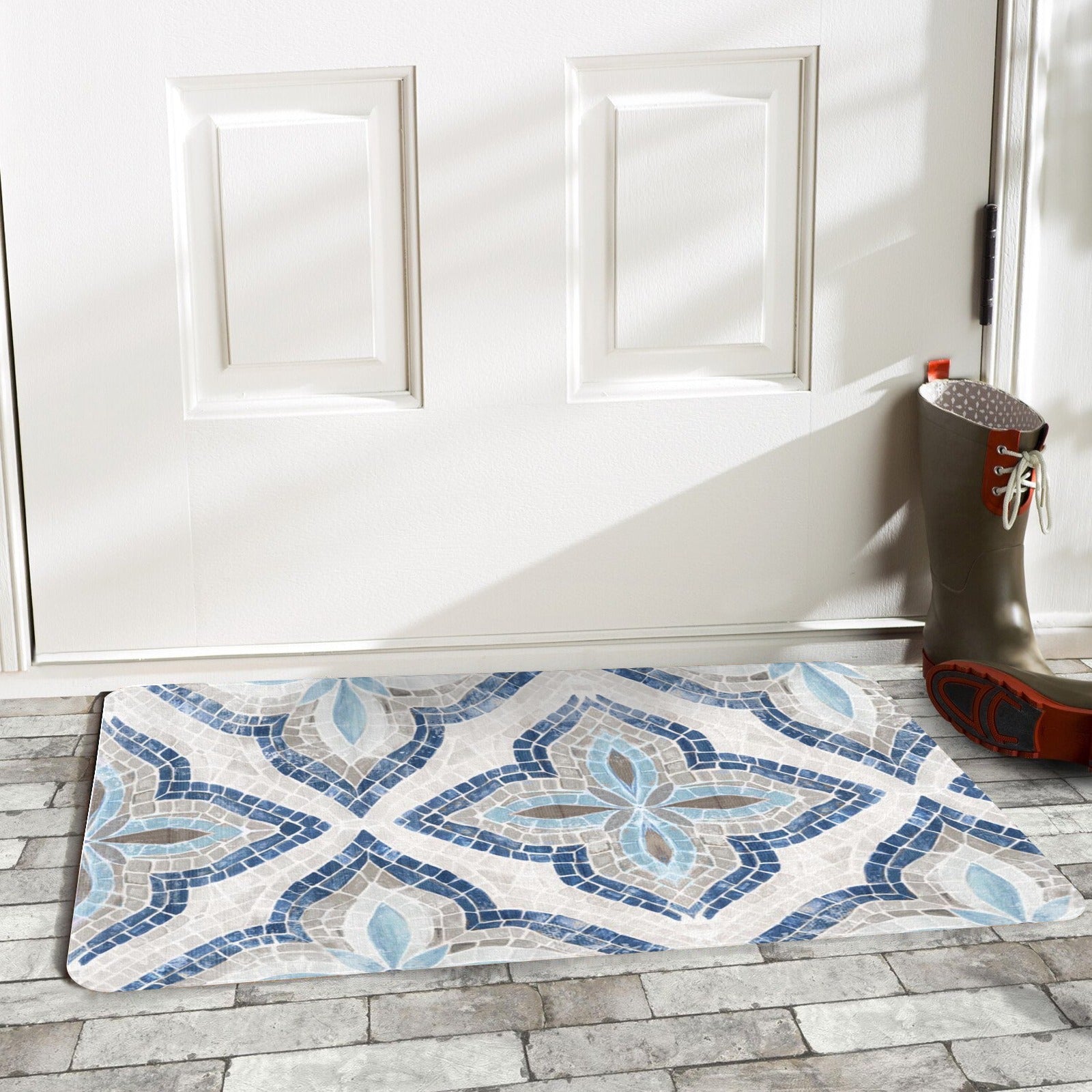 Blue mosaic pattern doormat on brick patio, entrance door and boots visible.