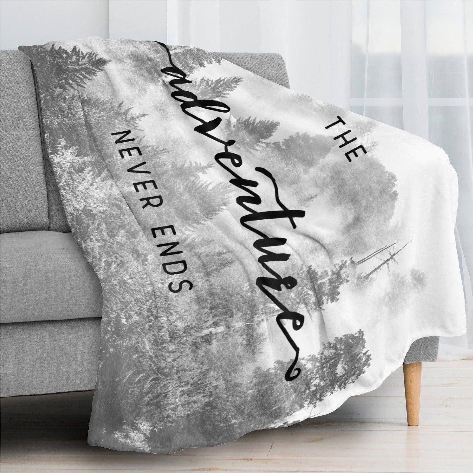 Black and white forest flannel blanket with "Adventure Never Ends" text. Perfect gift.