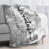 Black and white forest flannel blanket with "Adventure Never Ends" text. Perfect gift.