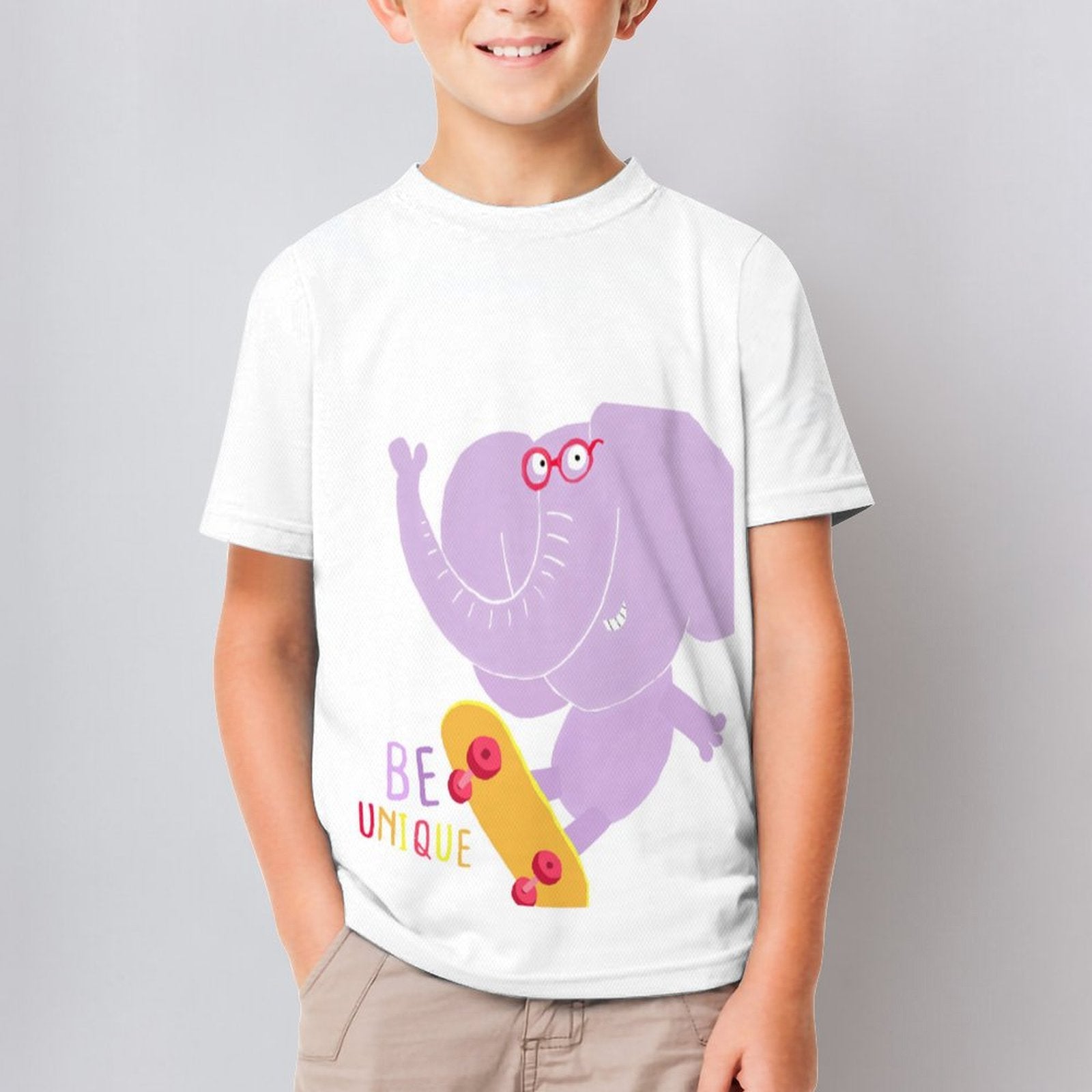 Kids short sleeve t-shirt with a skateboarding purple elephant and 'BE UNIQUE' text, perfect for summer wear.