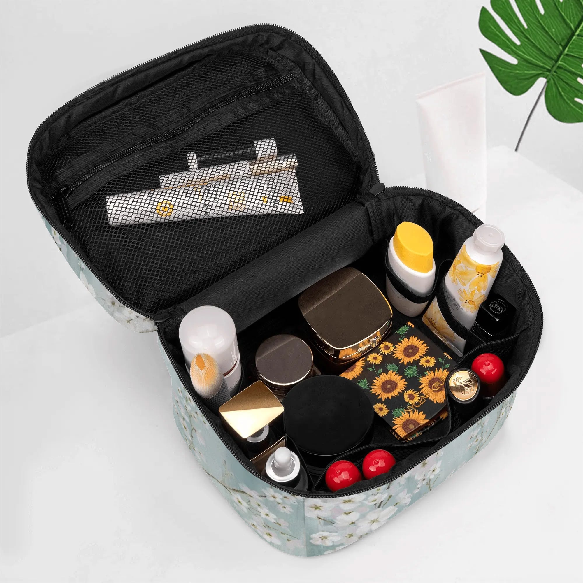 Plum blossom makeup bag open, filled with cosmetics. Travel cosmetic bag with floral design for women, PU leather waterproof.