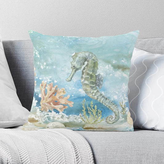 Watercolor seahorse and coral pillow cover on a couch. Perfect for home decor.