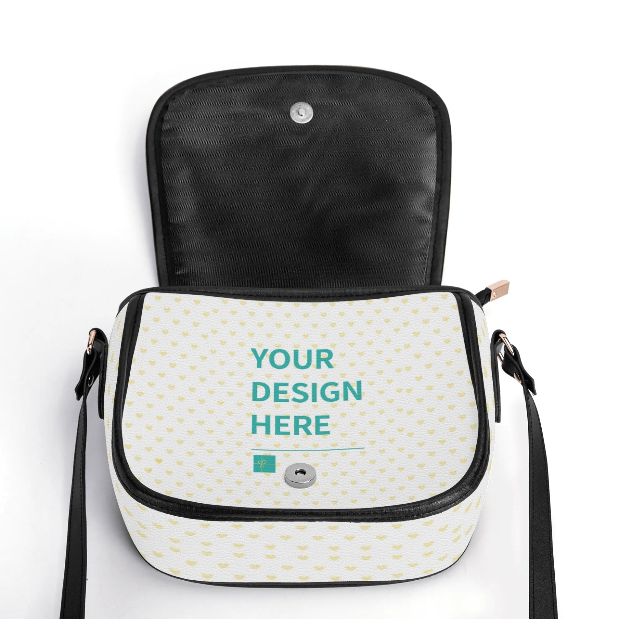 Customizable PU leather saddle bag with 'YOUR DESIGN HERE' on white heart pattern, black accents, and black adjustable strap