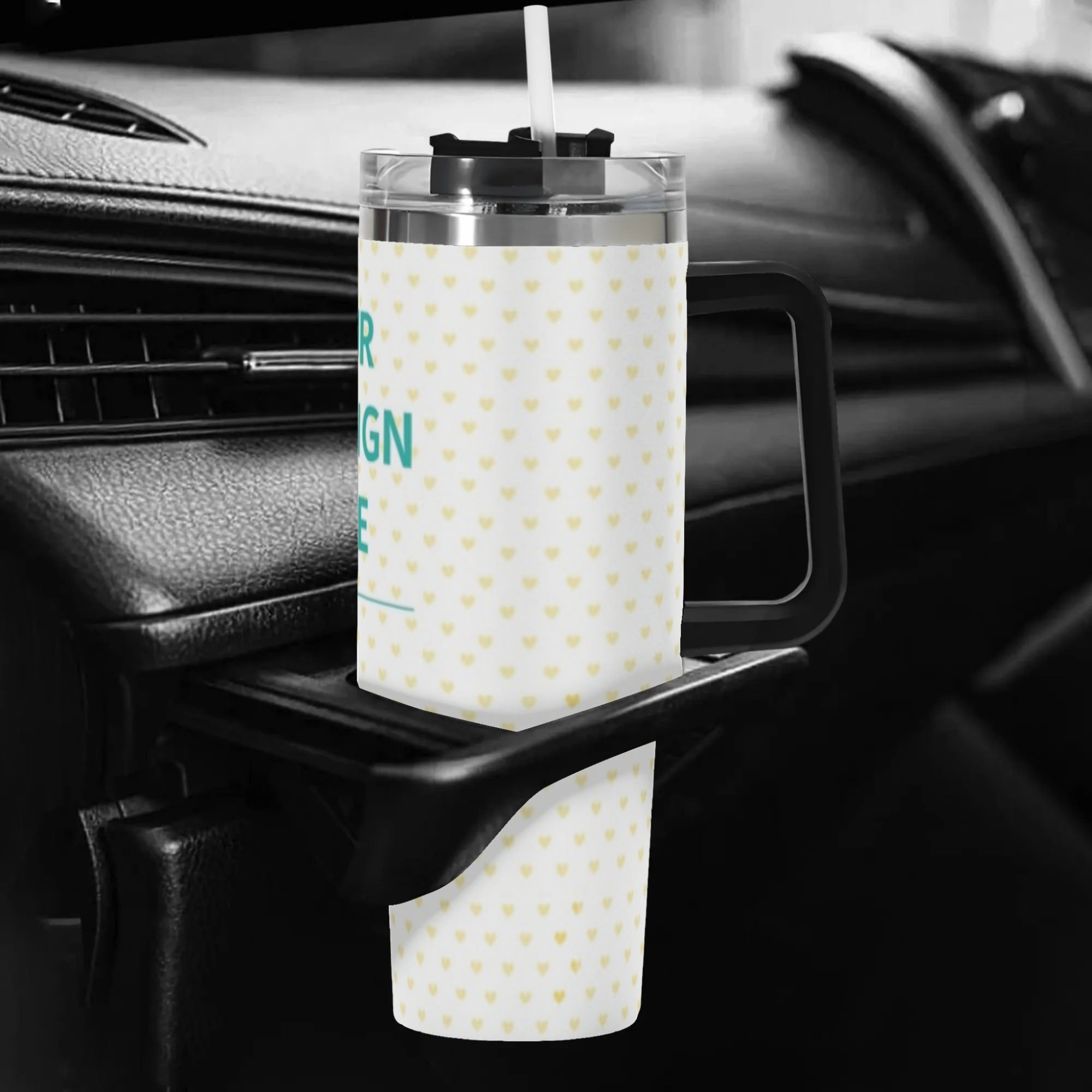 Personalized 40oz Stainless Steel Tumbler with heart pattern, black handle, and straw, in car