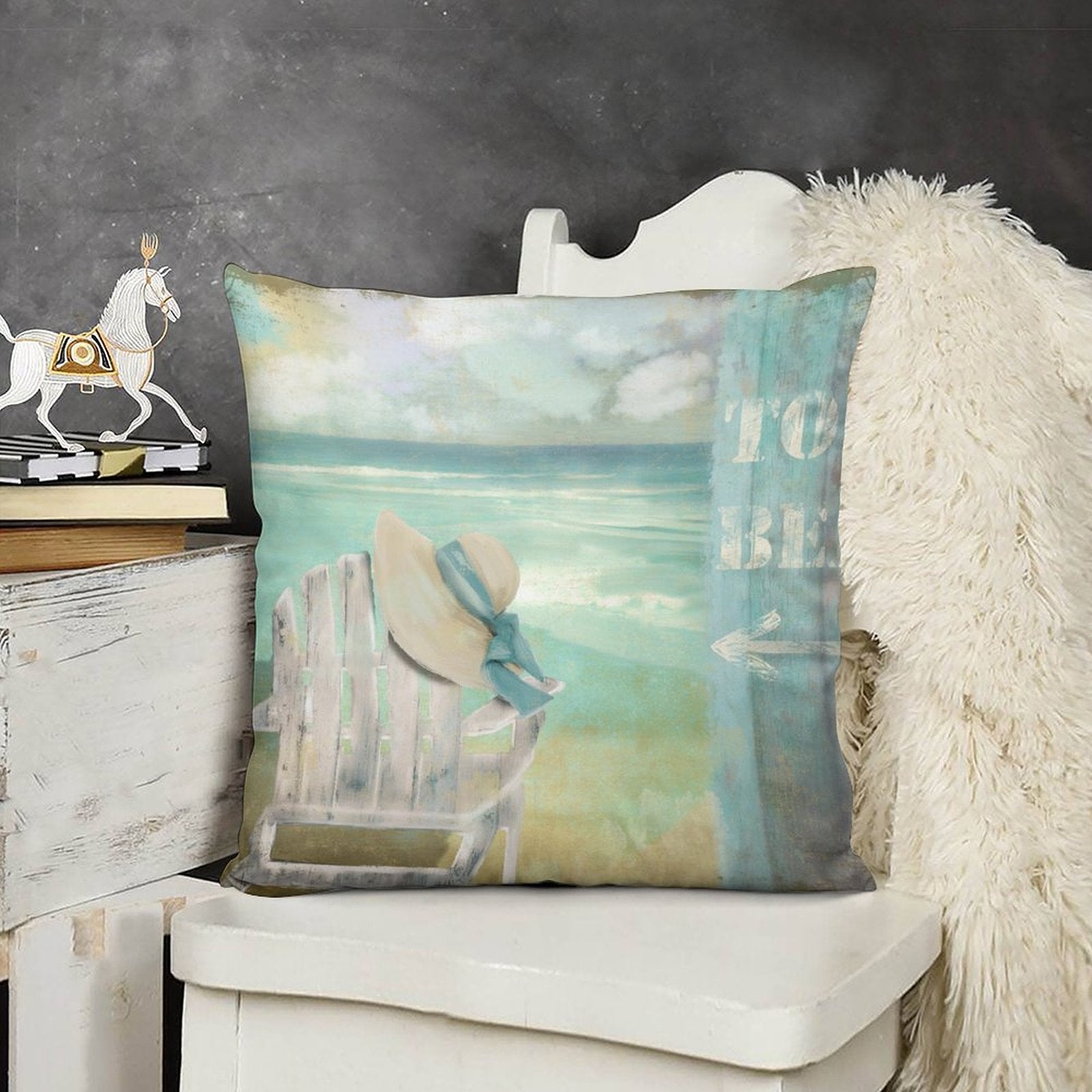 Short plush pillow cover with beach scene, "TO BE" sign, hat and chair; soft and cozy, for sofa or bed.