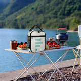 Customizable lunch tote bag with 'YOUR DESIGN HERE' on a picnic table by the lake, perfect for work or travel.