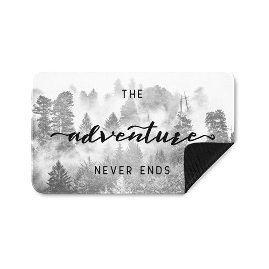 Forest entrance doormat with "The Adventure Never Ends" quote, rubber floor mat for home decor.