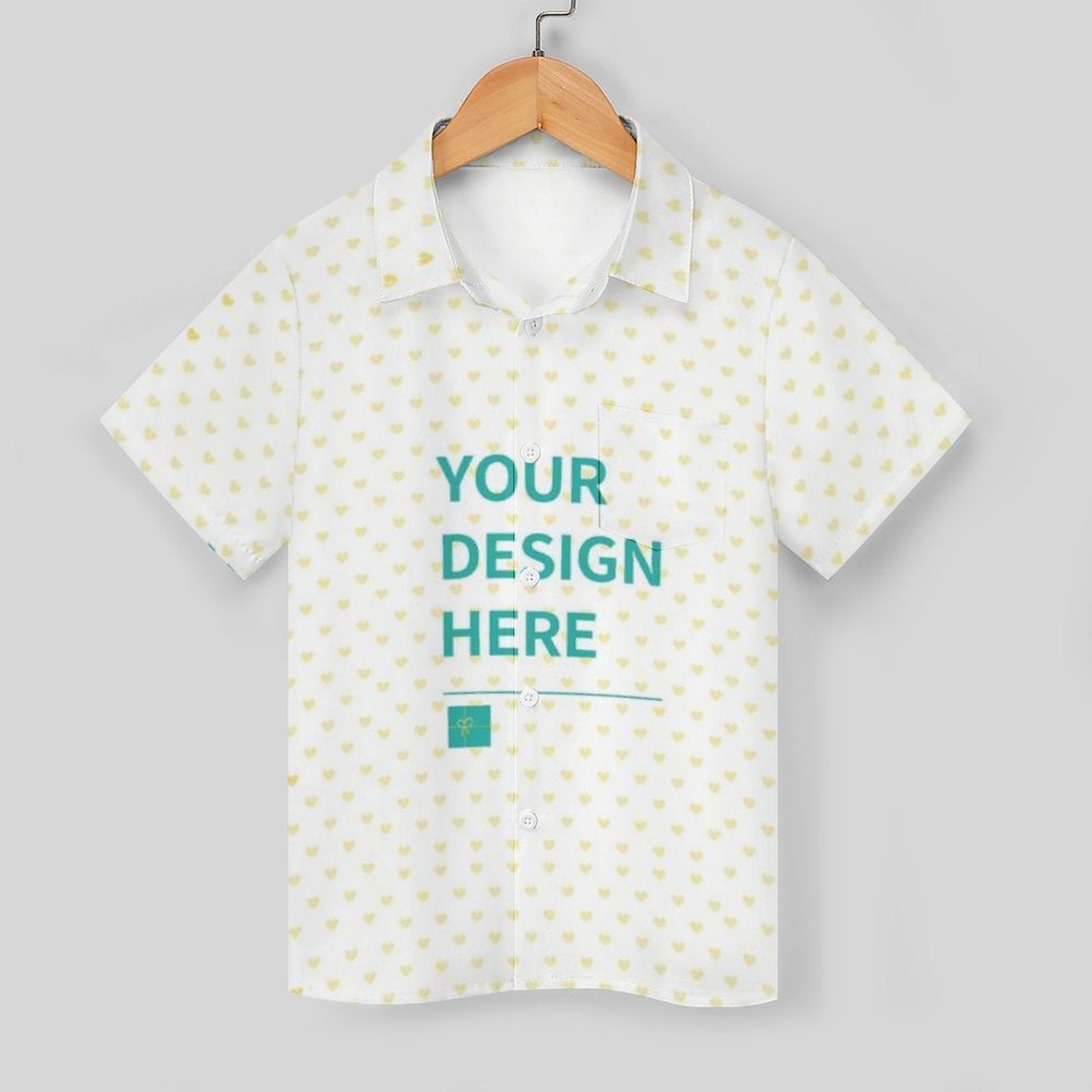 Customizable kids' polo shirt. White with yellow heart pattern and 'Your Design Here' text.