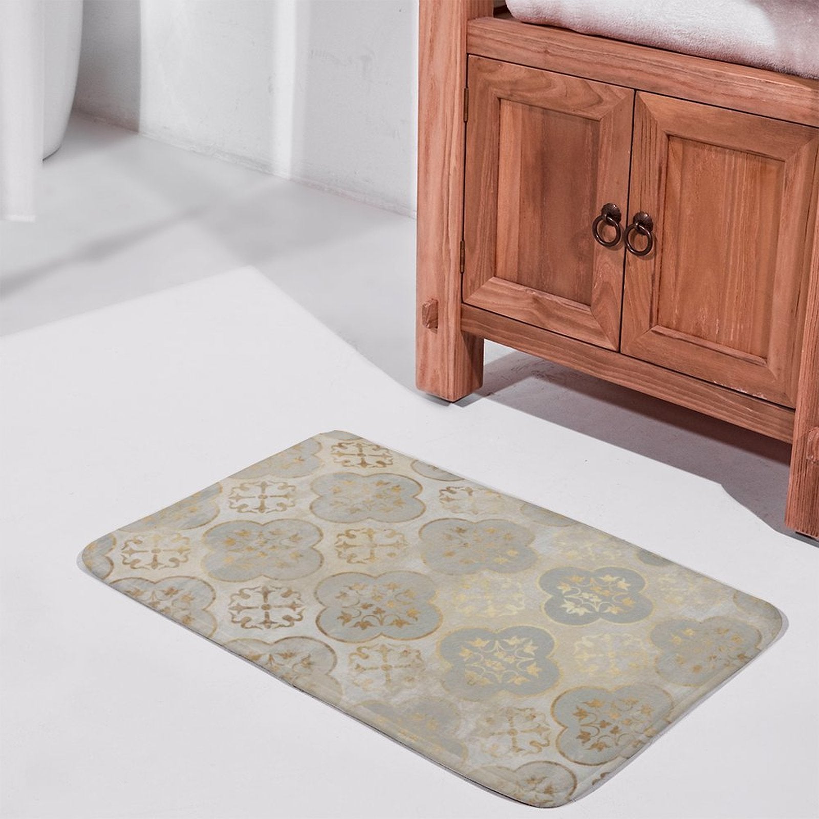 Grey and gold floral patterned bathroom rug in front of a wooden cabinet, non-slip for bathroom
