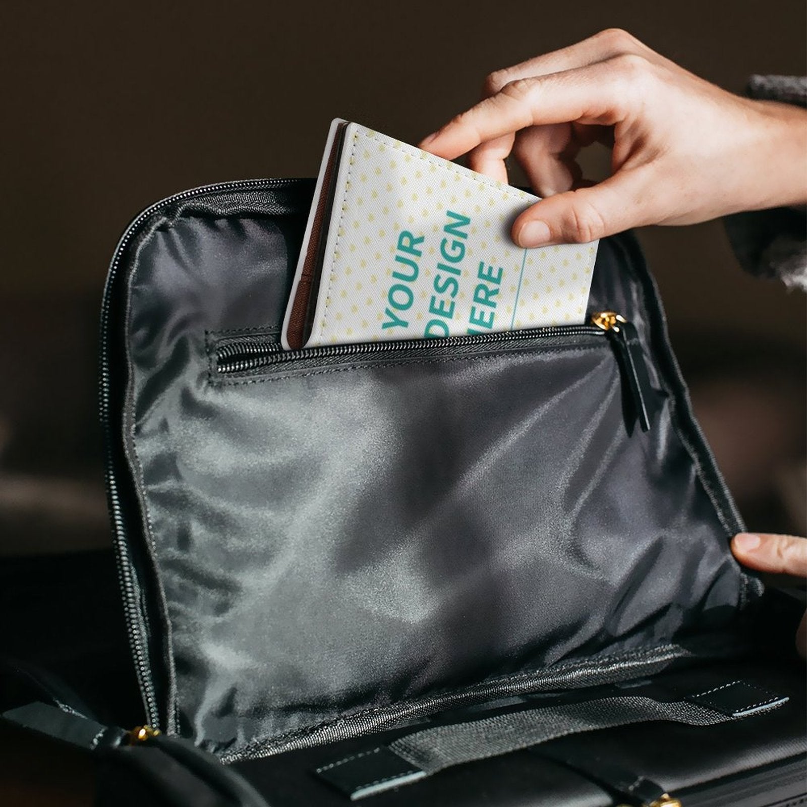 Custom passport holder with 'YOUR DESIGN HERE' text, placed in a black bag. PU material travel gift.