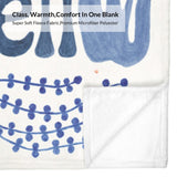 Coastal blue flannel blanket detail with 'Class, Warmth, Comfort' design, made of fleece and polyester.