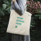 Customizable canvas tote bag with YOUR DESIGN HERE design, perfect for carrying flowers or shopping.