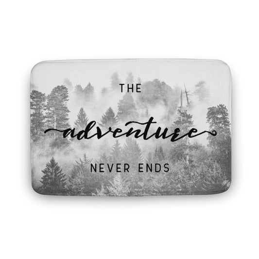 Coral velvet bath rug with "The adventure NEVER ENDS" in a misty forest design for bathroom.