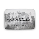 Coral velvet bath rug with "The adventure NEVER ENDS" in a misty forest design for bathroom.