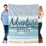 Blue Beach Coastal Flannel Blanket with 'Let The Adventure Begin' text, held by a man and woman, perfect for sofa or bed