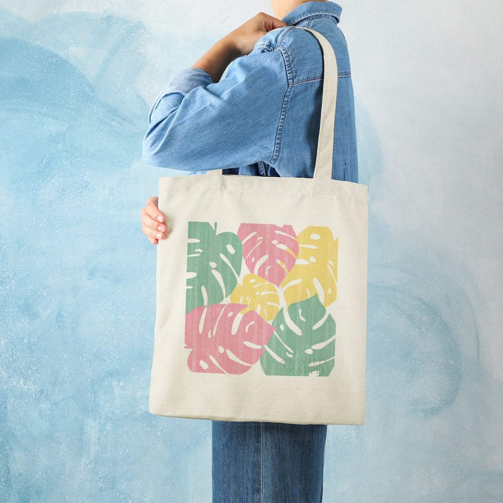 Canvas tote bag with Monstera leaf print in pink, green, and yellow. Eco-friendly cotton shopping bag for women.