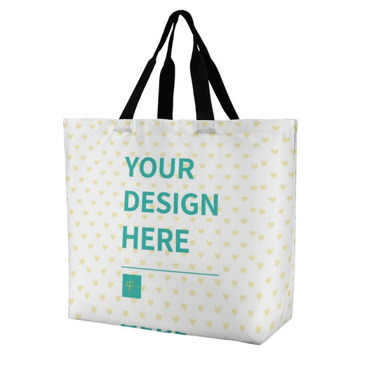 Custom tote bag with "YOUR DESIGN HERE" text, heart pattern, and black handles, ideal for personalized shopping.