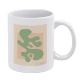 White ceramic coffee mug with green abstract design, Shape Up IV, by Wild Apple, a perfect customizable gift