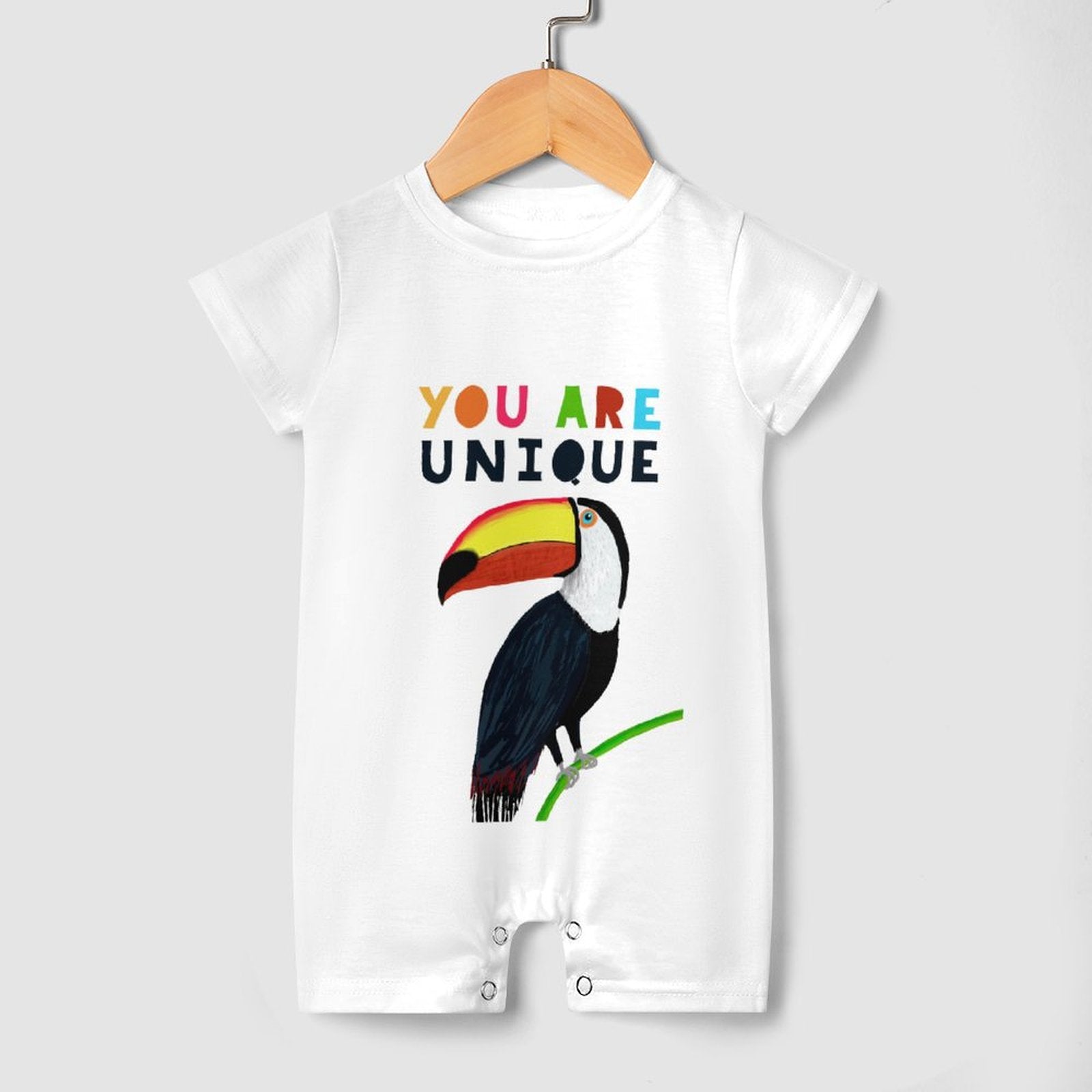 Soft cotton baby romper with colorful toucan design and YOU ARE UNIQUE text