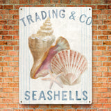 Metal sign with Seashells art, perfect for beach decor, mounted on brick wall