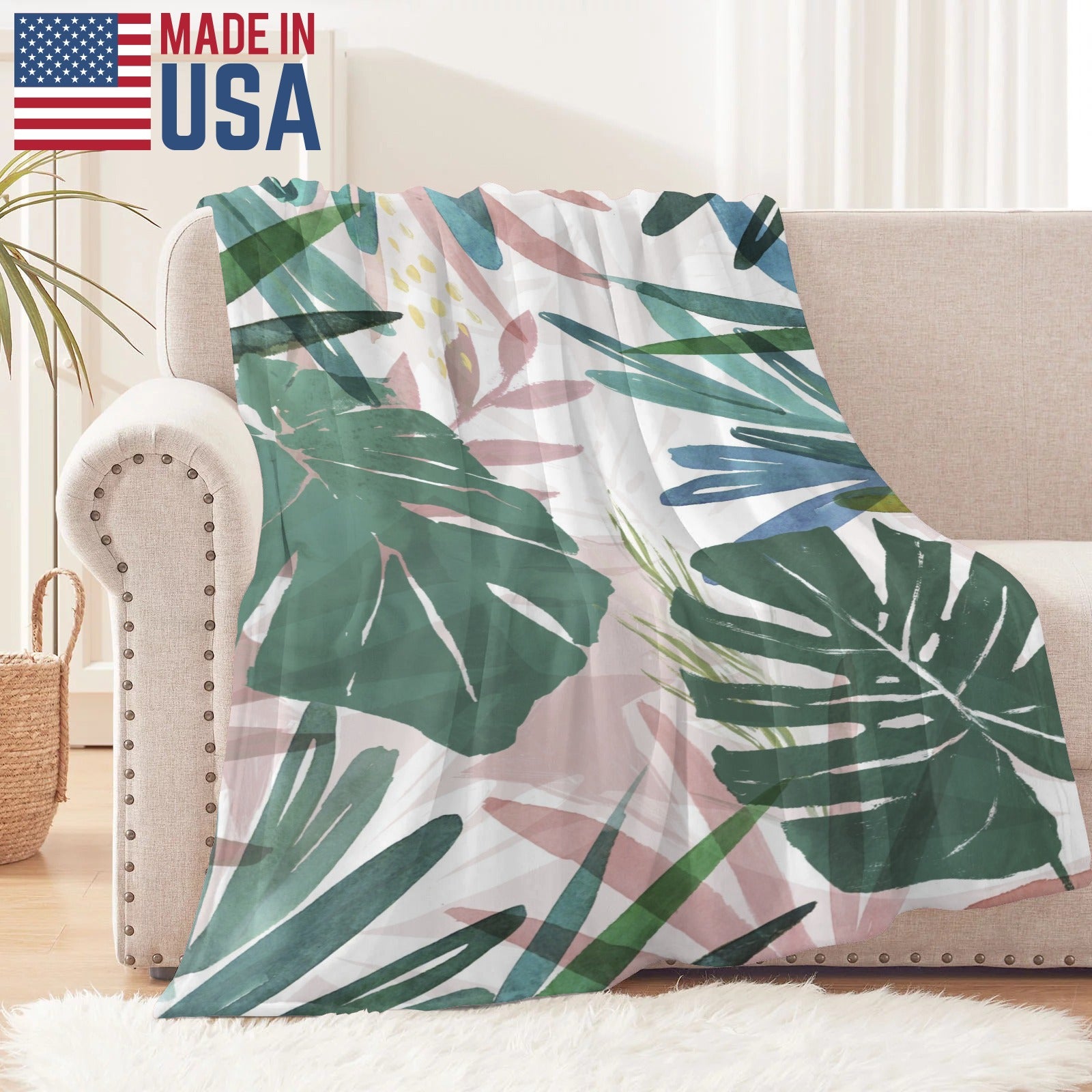 USA-made tropical leaves flannel blanket. Green, pink, and blue watercolor design for sofa.