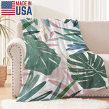 USA-made tropical leaves flannel blanket. Green, pink, and blue watercolor design for sofa.
