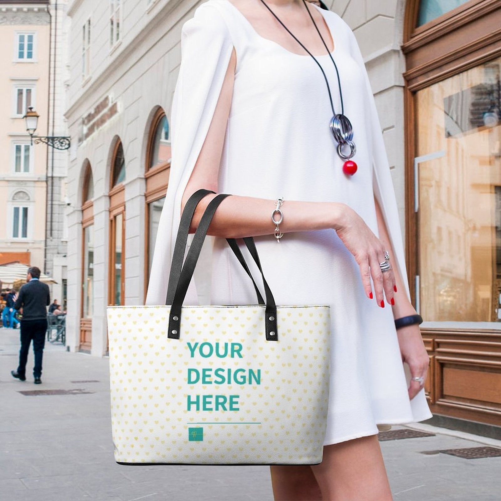 Customizable leather tote bag with heart pattern, "Your design here" text, black handles, perfect for travel and shopping