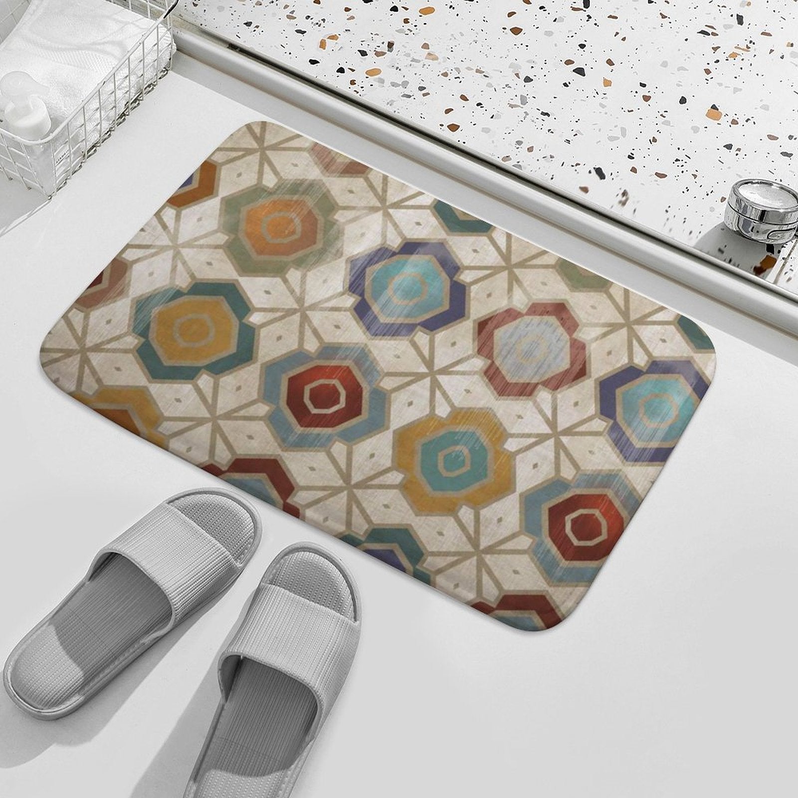 Geometric bath rug with non-slip properties in a bathroom setting, next to grey slippers and towels.