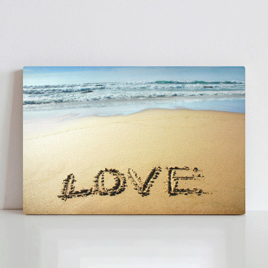 Love canvas print featuring "LOVE" written in sand with waves. Artwork for home decor.