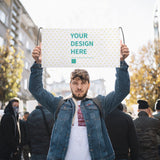 Custom hand waving flag with "YOUR DESIGN HERE" design, held by a man in a crowd, cheering and support