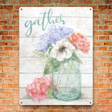 Metal sign with watercolor floral arrangement, featuring 'gather' and 'love' text. Home decor with flowers in mason jar.