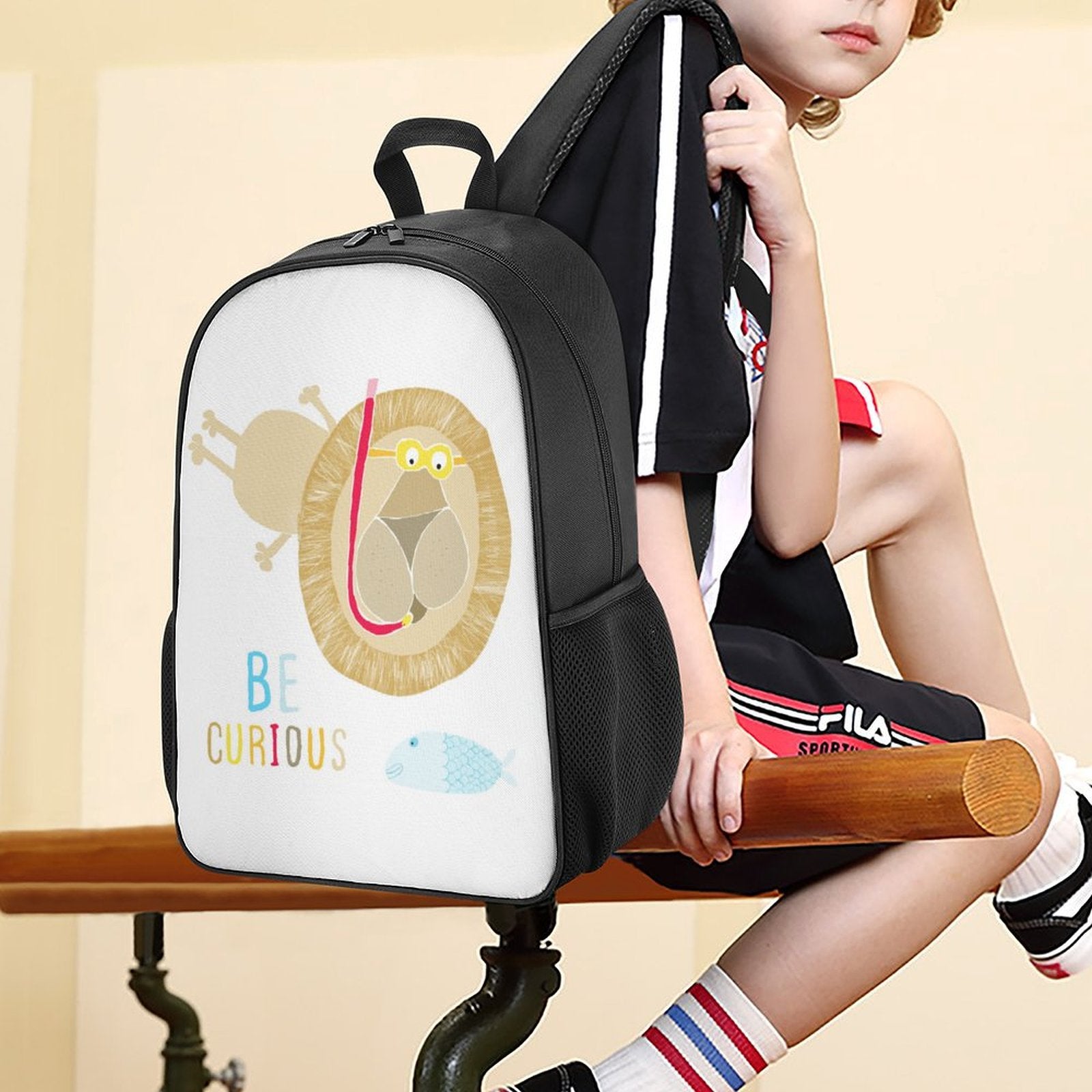 Kids school backpack with lion graphic, side pockets, and 'Be Curious' text, perfect for school or travel adventures.
