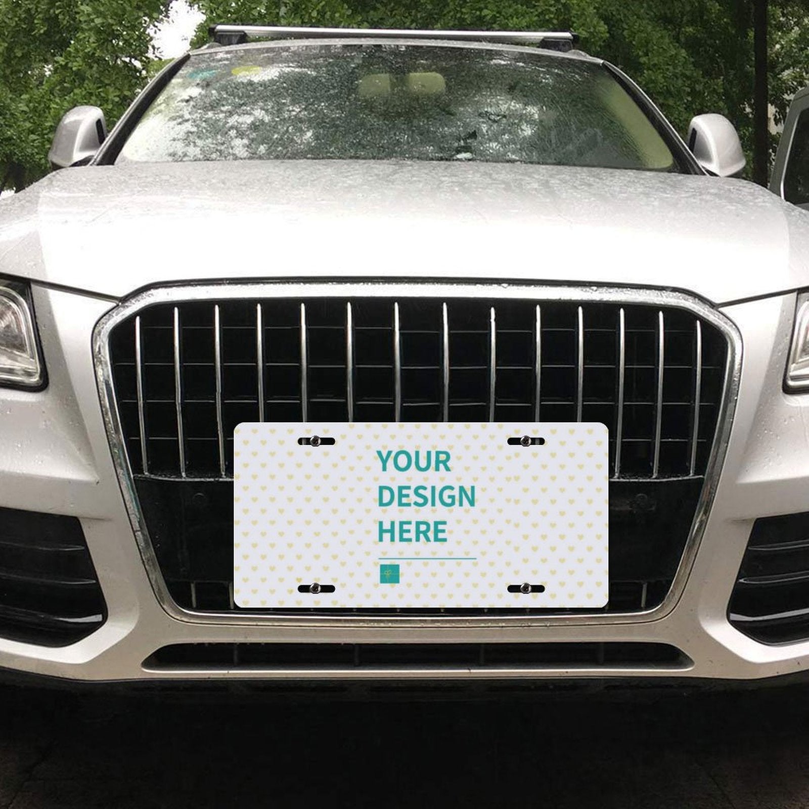 Customizable aluminum license plate with "YOUR DESIGN HERE" design on front of a car, waterproof and rust-resistant.