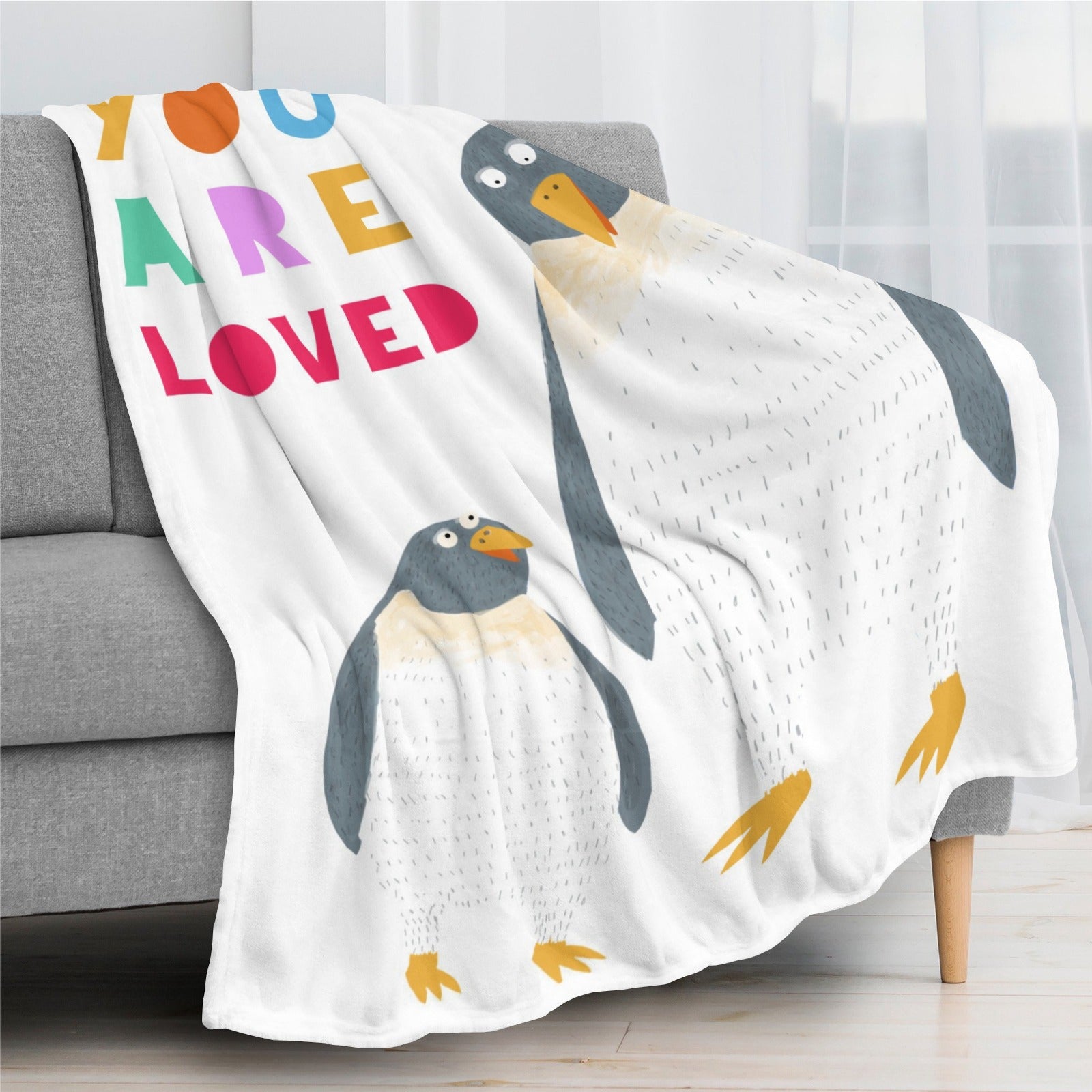 Penguin flannel blanket with "YOU ARE LOVED" text. Super soft, cozy kids' bedding.