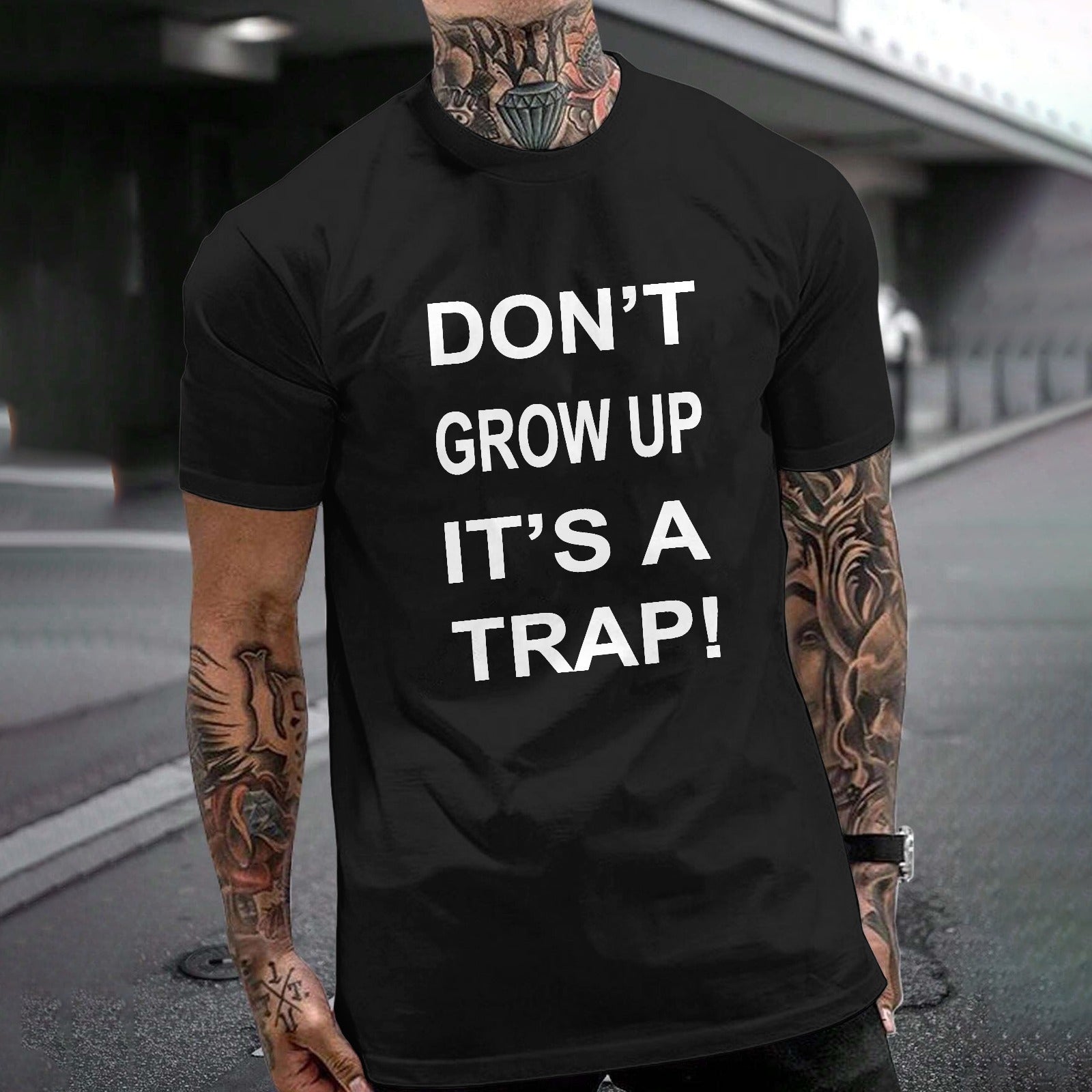 Black Gildan Unisex T-shirt with "DON'T GROW UP IT'S A TRAP!" text. Cotton fabric, perfect for MyArtsyGift.