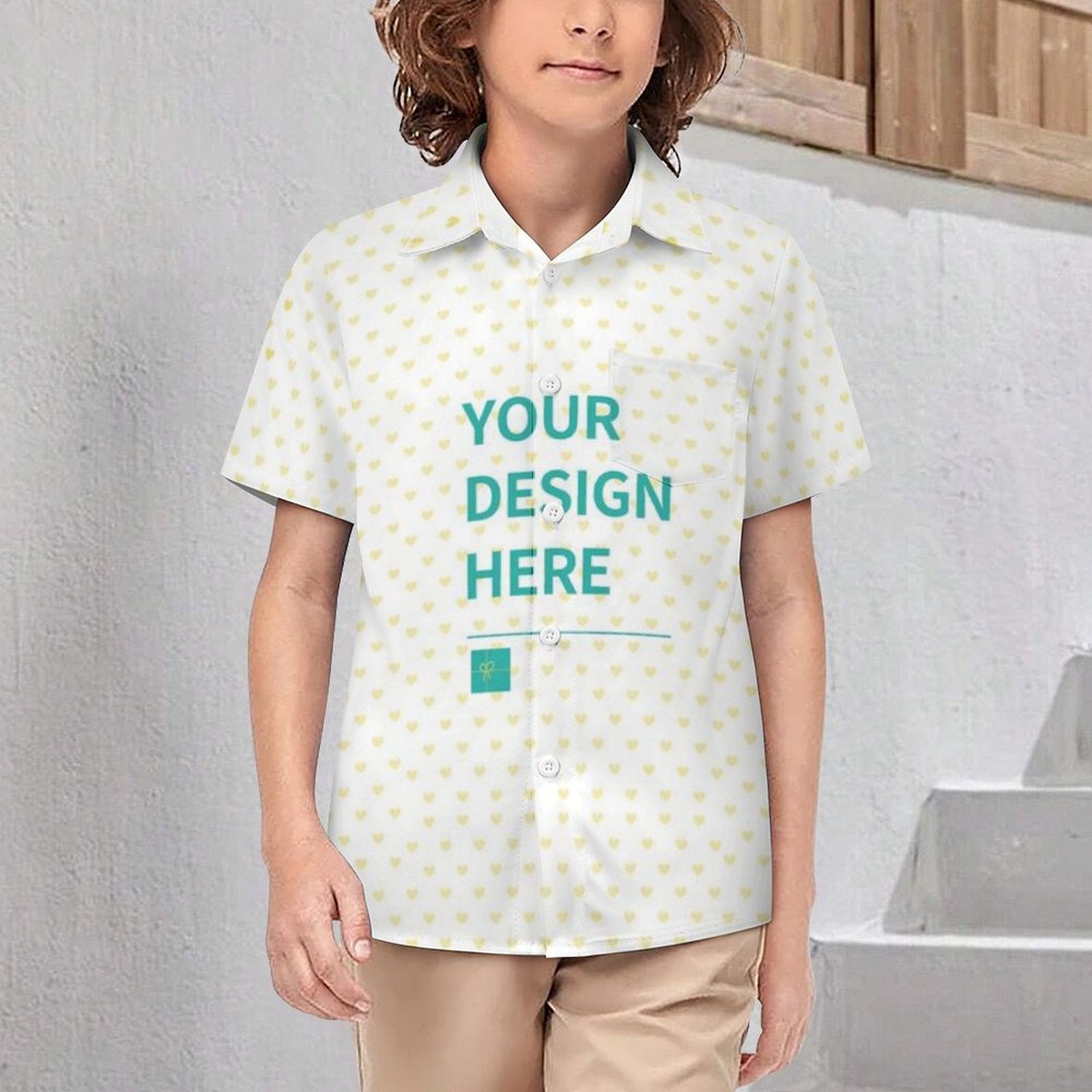 Customizable kids polo shirt with 'Your Design Here' text. White shirt with yellow heart pattern, personalized clothing.