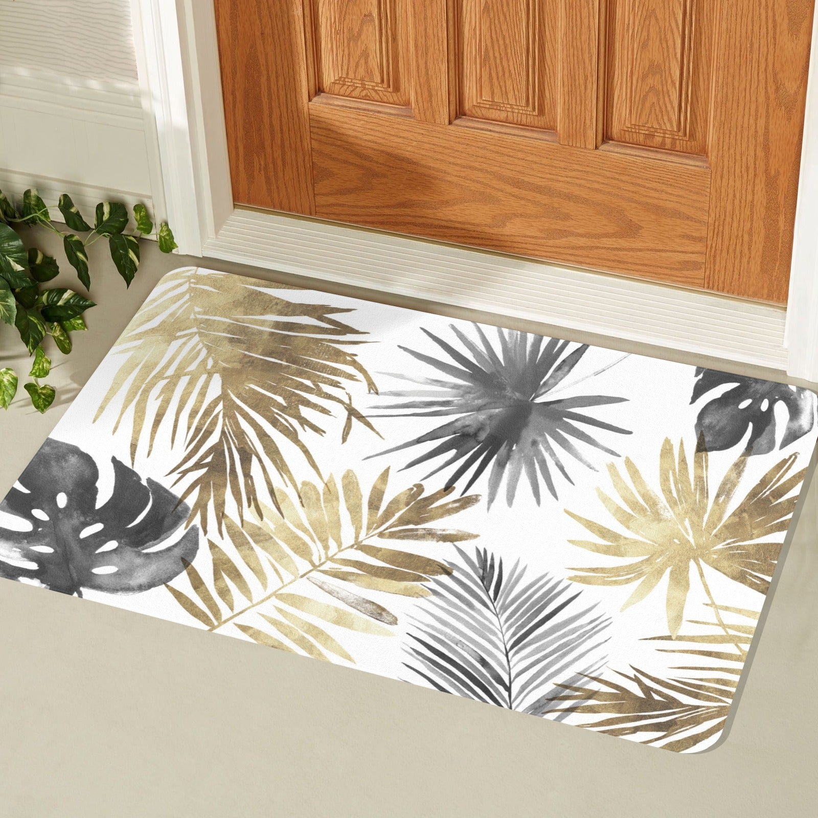 Tropical leaves entrance doormat in gold, gray and black near wooden door