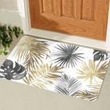 Tropical leaves entrance doormat in gold, gray and black near wooden door