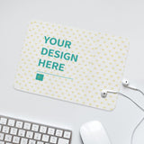 Custom desk mat with "YOUR DESIGN HERE" text, white mouse, keyboard, and earbuds, office accessory