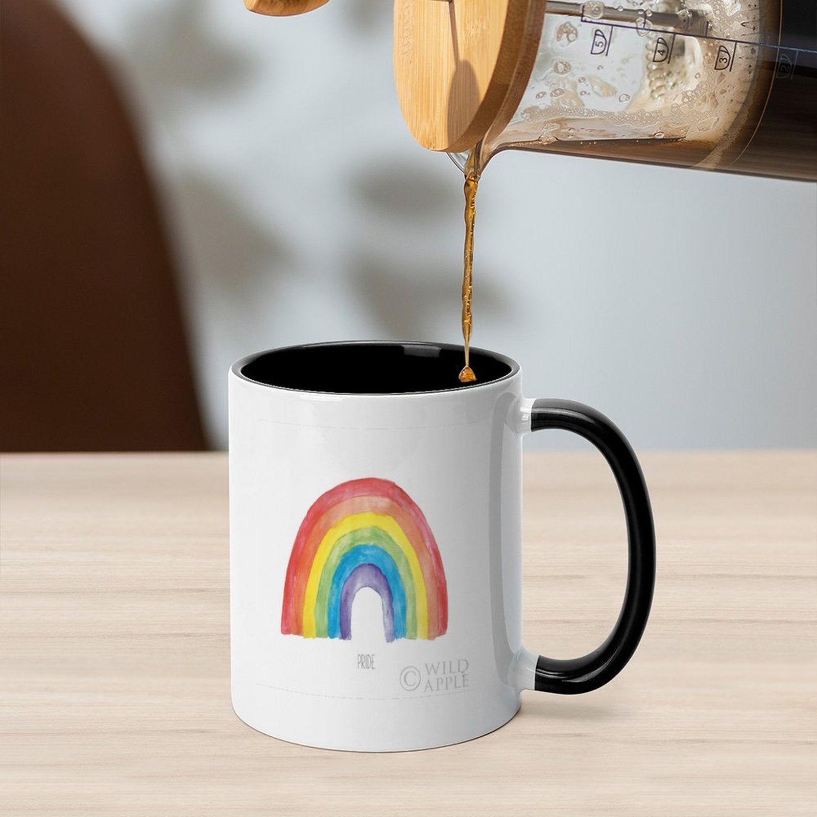 White ceramic Pride mug with rainbow design and black handle, pouring coffee, customizable gift from MyArtsyGift.