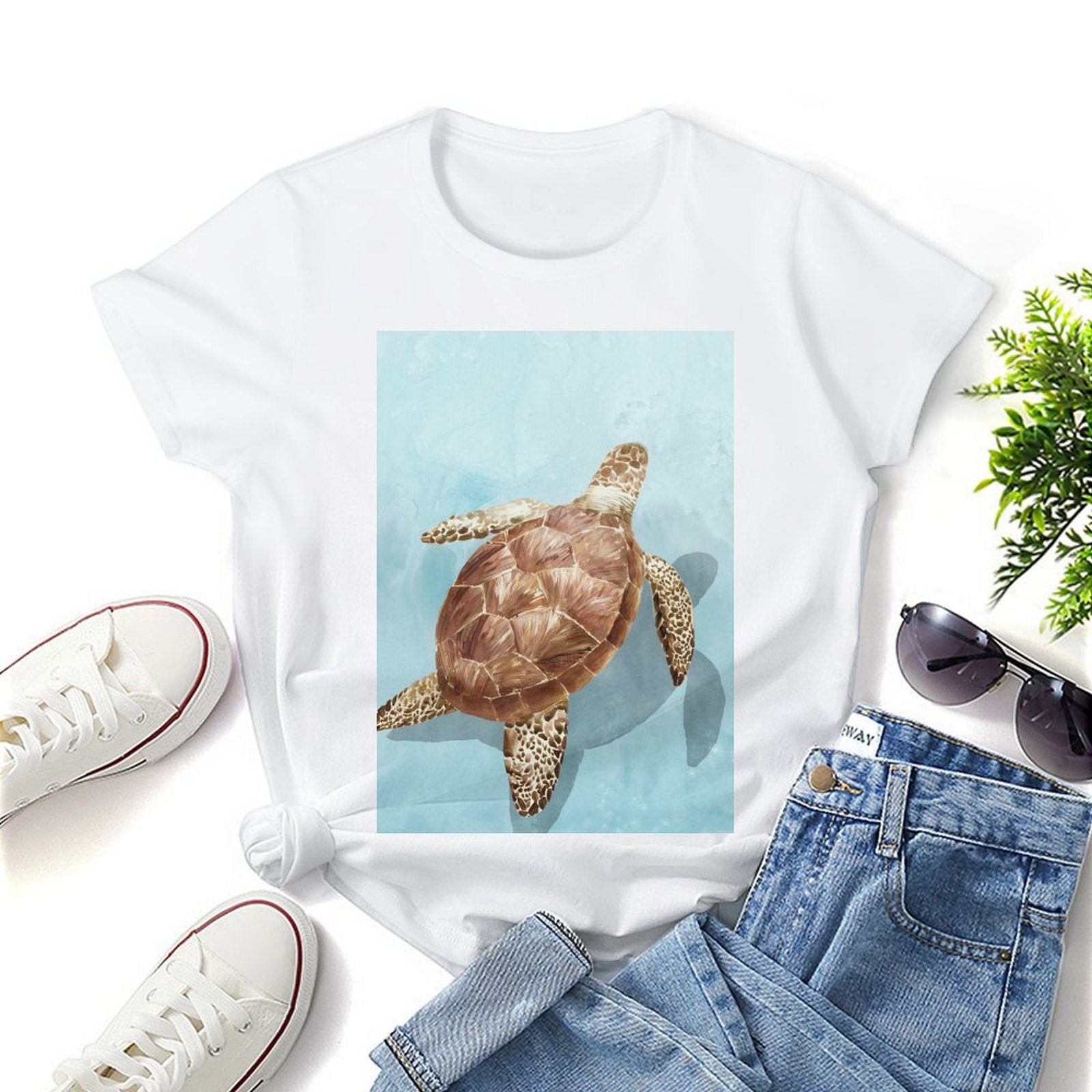 White women's short sleeve crewneck t-shirt with sea turtle graphic print, stylish summer look.