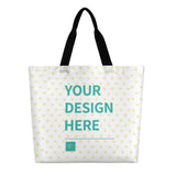 Customizable canvas tote bag with "YOUR DESIGN HERE" text, heart pattern, black handles, perfect for gifts.