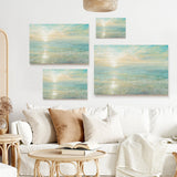 Sunrise canvas print set for wall decor with soft colors, made in the USA. Ocean scenery art above white sofa.
